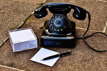 rotary phone on ground beside pen and sticky note thumbnail
