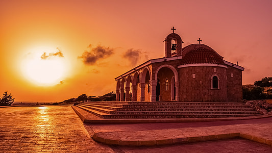 brown concrete church beside trees during golden hour thumbnail