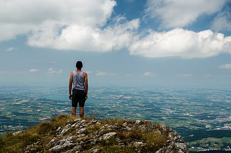 man standing on rocky mountain during daytime thumbnail