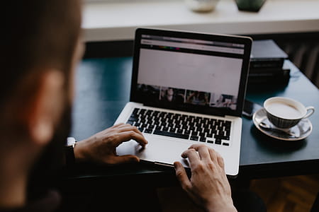 Male working with a laptop and a cup of coffee thumbnail