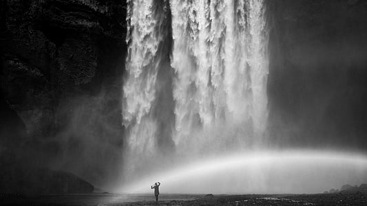 person standing front of waterfalls thumbnail