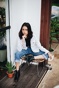 woman sitting on chair white resting her chin on her hand thumbnail