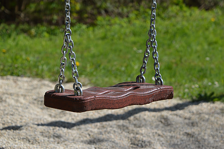 focus photography of brown playground swing near green grass thumbnail