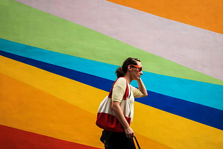 woman walking beside multicolored wall thumbnail