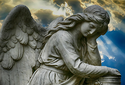 white ceramic angel statue under gray clouds thumbnail