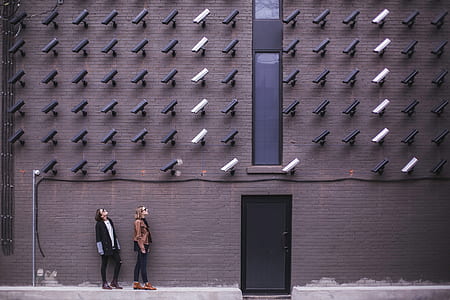 two women standing under CCTV cameras thumbnail
