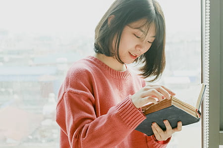 woman reading book beside glass wall thumbnail