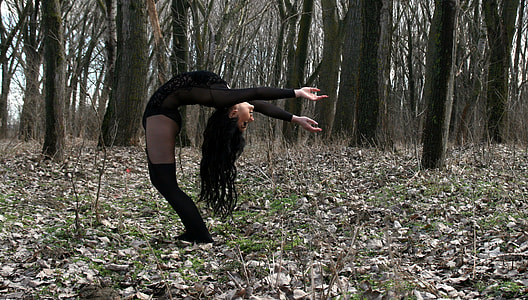 woman with black long sleeve top bending to the ground thumbnail