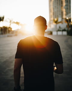 man in black shirt walking towards building thumbnail