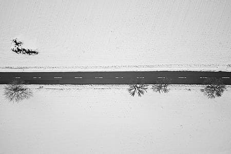 aerial photography of black road near trees and snow ground thumbnail
