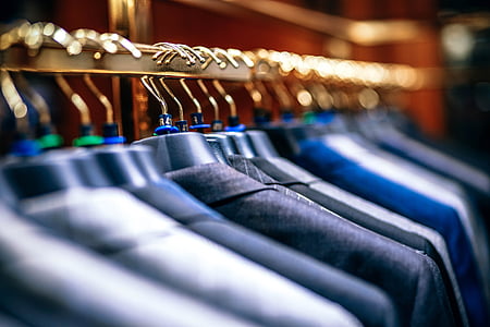 shallow focus photography of suit jackets hanging on clothes rack thumbnail
