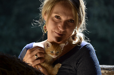 woman holding orange tabby kitten thumbnail