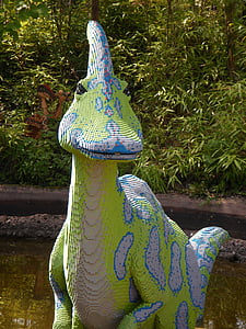 green and blue animal figure near green leafed plants thumbnail