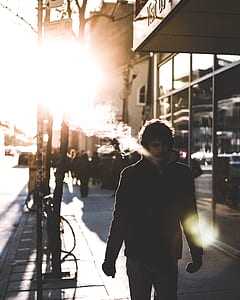 man smoking white walking near glass buildings thumbnail