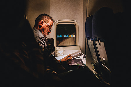 man holding paper while reading near window thumbnail