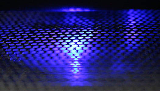 Abstract background of metallic mesh with blue and white light shining through thumbnail