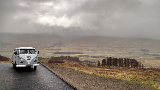 white and blue Volkswagen van in middle of road thumbnail