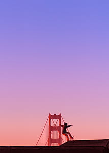 person skating on Golden Gate Bridge under purple sky thumbnail