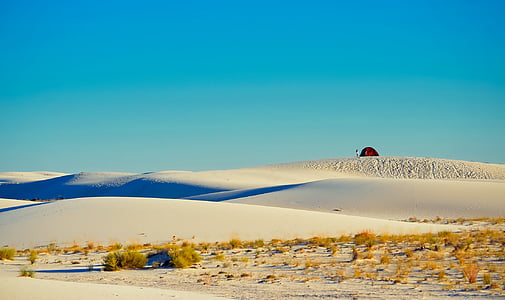 person standing in front of red and black tent at the deserted area thumbnail