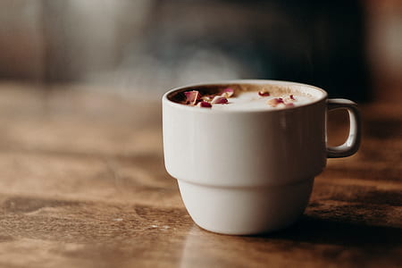 white ceramic cup with milk on brown wooden panel thumbnail
