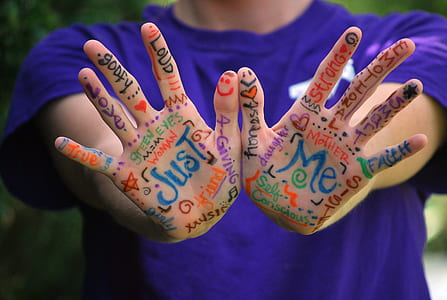 person wearing purple crew-neck t-shirt with hand art thumbnail