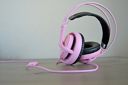 closeup photo of pink corded headphones on wooden panel thumbnail