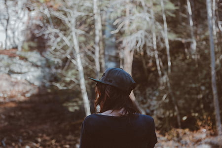 selective focus photography of woman walking under green leafed tree at daytime thumbnail