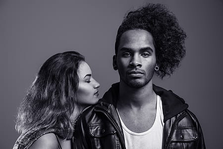 woman closing her eyes beside man in grayscale photo thumbnail