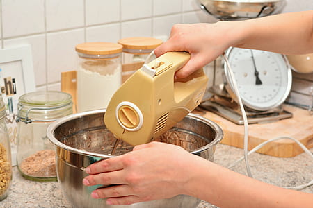 man using electric mixer while touching gray stainless steel bowl thumbnail