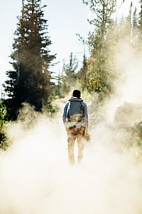 man walking smoke pathway during daytime thumbnail