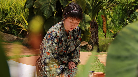 woman kneeling near brown flower pot thumbnail