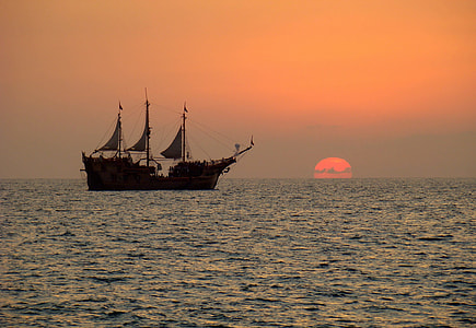 silhouette of ship on sea at golden hour thumbnail