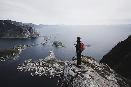 man standing on cliff during daytime thumbnail