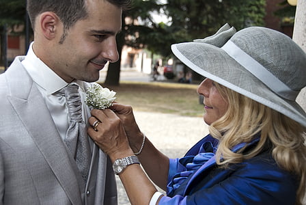 woman putting flower brooch on man's blazer thumbnail