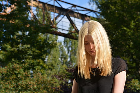 blonde-haired woman wearing black shirt facing down thumbnail