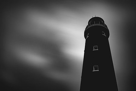 silhouette lighthouse under gray sky thumbnail