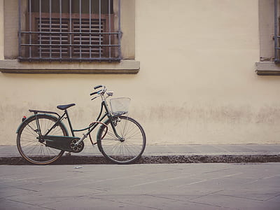 black bicycle parked beside wall thumbnail