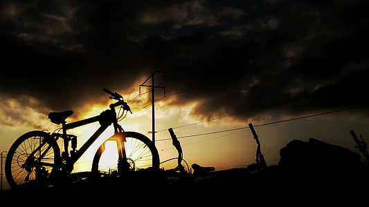 silhouette of black full-suspension mountain bike during sunset thumbnail