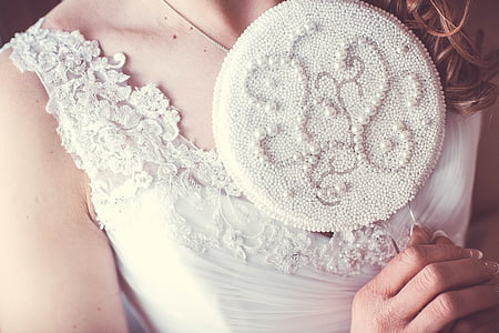 woman in white floral dress holding hand mirror thumbnail