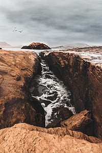 stream between cliff under nimbus clouds thumbnail