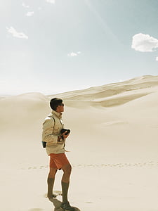 man in black jacket standing on desert thumbnail