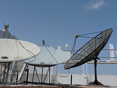 three round black, gray, and white satellite under blue and white skies thumbnail