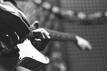 Grayscale Photo of Person Holding Electric Guitar thumbnail