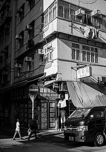 grayscale photo of black vehicle and gray building thumbnail