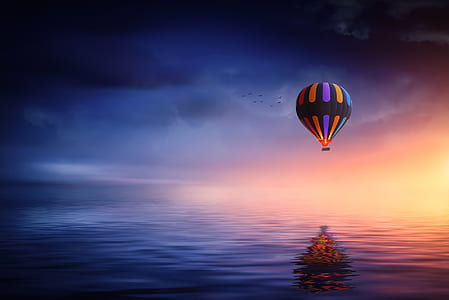 hot air balloon flying on near near water thumbnail
