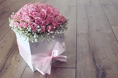 pink rose flower arrangement in white box on brown wooden surface thumbnail