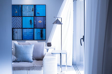 white fabric sofa with throw pillow beside lamp with table inside the room thumbnail