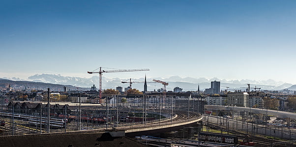 aerial photography of empty road overlooking cranes under blue sky at daytime thumbnail