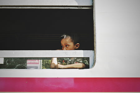 boy standing in front of window thumbnail