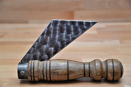 brown handled folding knife on brown wooden surface thumbnail